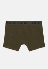 Oliven grønne boxershorts med sort elastisk talje, der har Björn Borg-logo og synlig syning på frontpanelerne.