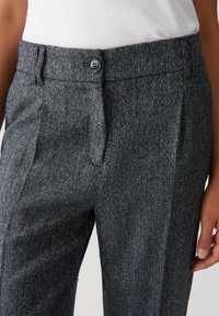 Grau gestreifte Hosen mit glatter Textur, tailliertem Schnitt, vorderen Falten und einem einzelnen Knopfverschluss am Bund.