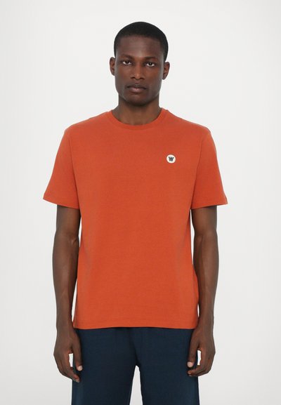 Short-sleeved orange T-shirt in a smooth cotton material, featuring a small white logo on the chest and a crew neckline.