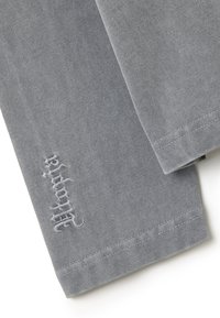 Grijze katoenen broek met een zachte textuur en een subtiel geborduurd logo op de zoom. Het ontwerp heeft schone naden en een rechte snit.