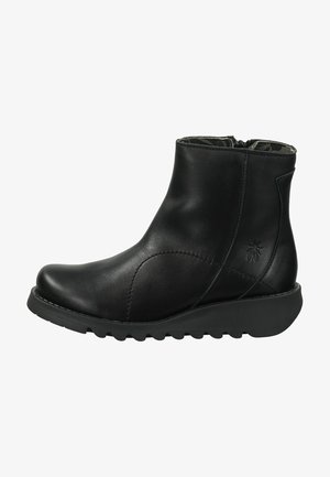 Bottines en cuir noir avec un design élégant, un bout rond et une semelle en caoutchouc texturé. Dotées d'une fermeture éclair sur le côté et de subtils accents cousus.