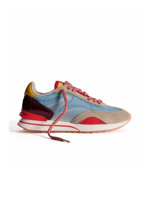 Zapatilla multicolor con cuero azul, gamuza beige, acentos de goma roja y cordones a rayas rojos. Punta redondeada y suela acolchada.