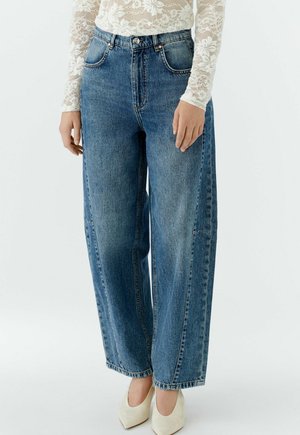 Hellblaue weit geschnittene Jeans aus Denim mit hoher Taille, ausgestattet mit Vordertaschen, einem Knopfverschluss und dezenten Nahtdetails.