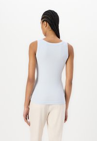 Lichtblauw tanktop met een aansluitend ontwerp, geribbelde textuur en een brede halslijn. De achterkant heeft een gladde afwerking en een rechte zoom.