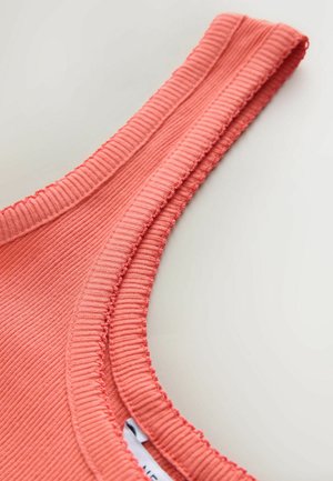 Maiou din material cu caneluri coral, cu un decolteu rotund și detalii cusute de-a lungul marginilor, având o etichetă interioară parțial vizibilă.