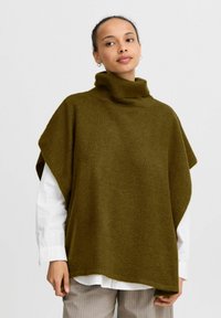Poncho morbido di colore verde oliva, con collo alto a imbuto, vestibilità ampia e maniche larghe. Design minimalista senza chiusure visibili.