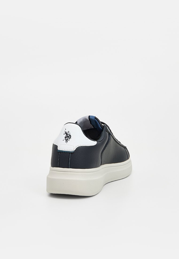 Baskets en cuir marine avec accent de talon blanc, surface texturée et semelle en caoutchouc de couleur claire. Présente un détail logotype sur le talon.