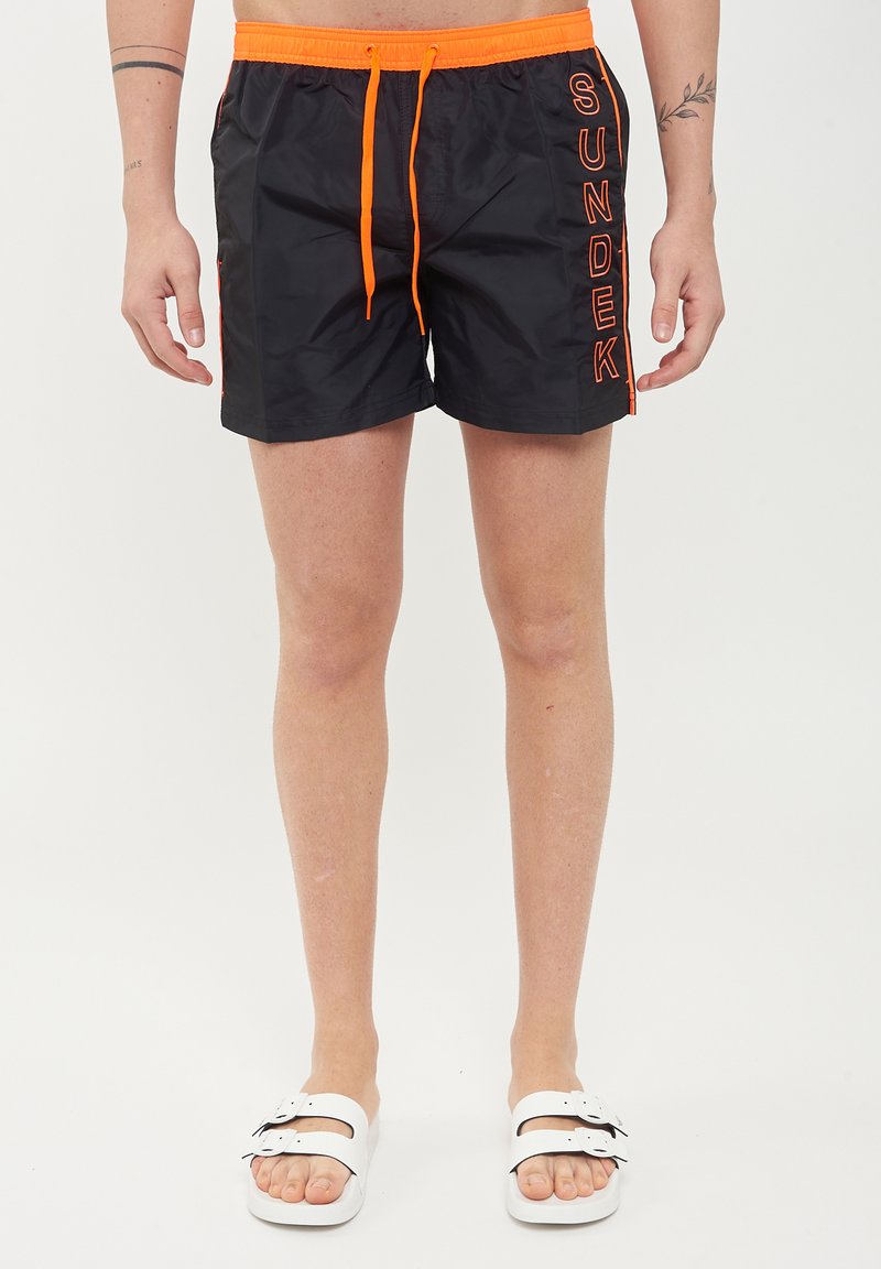 Pantaloni da bagno neri con coulisse arancione e dettaglio del logo "SUNDEK". Realizzati in tessuto morbido, offrono una vestibilità comoda e una lunghezza sopra il ginocchio.
