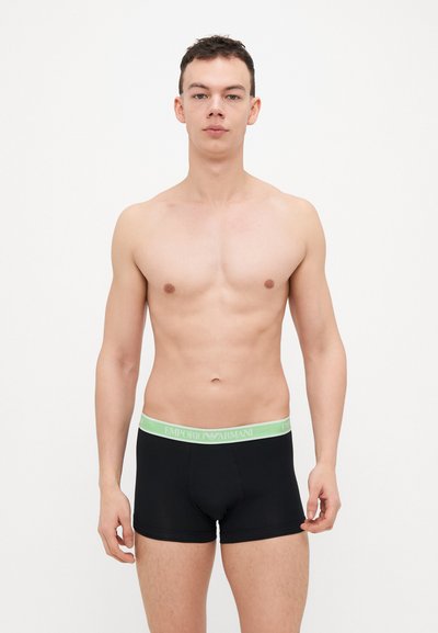 Boxer-briefs noirs avec une ceinture logo Emporio Armani vert clair, présentant une texture de tissu lisse et un design ajusté.