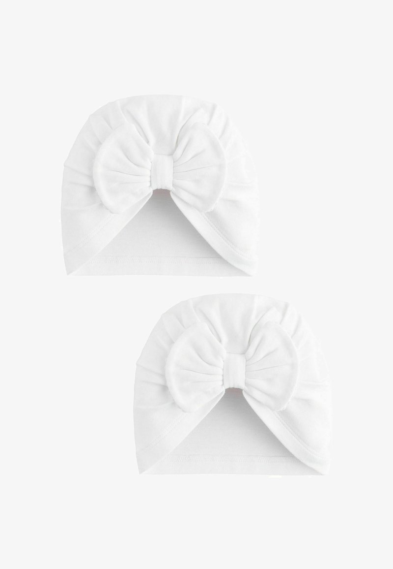 Due turbanti bianchi per neonati realizzati in tessuto morbido, ognuno con un grande fiocco sul davanti.