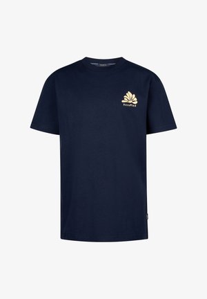 Barn iført marineblå PetroPlant-logo t-shirt, olivengrønne bukser og hvide sneakers, stående mod en ensfarvet hvid baggrund.