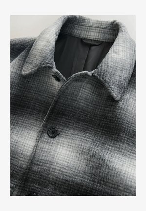 Jachetă gri cu carouri, fabricată dintr-un amestec de lână, cu guler și închidere cu nasturi negri. Interiorul este căptușit într-o culoare solidă.