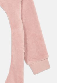 Zachte roze fleece mouwen met geribbelde boorden, in close-up van de gezellige stoftextuur en details.