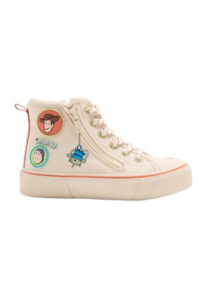 Flødefarvet high-top sneaker med tegneseriefigurer som patches, sidelås, hvide snørebånd med røde striber og beige gummisål med orange kant.