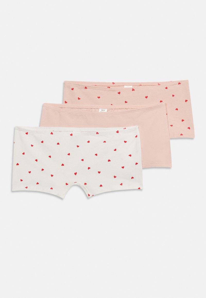 Τρία ζευγάρια παιδικά εσώρουχα τύπου μποξέρ για κορίτσια, σε λευκό και ανοιχτό ροζ, δύο με κόκκινα σχέδια καρδιών και ένα μονόχρωμο ανοιχτό ροζ, απλωμένα επίπεδα σε λευκό φόντο.