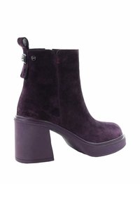 Fioletowa zamszowa botka za kostkę z grubym obcasem, gładką powierzchnią, zaokrąglonym czubkiem i pętelką z tyłu z metalowym akcentem.