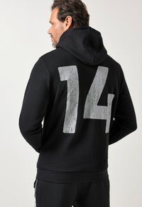 Felpa nera con cappuccio che presenta un grande numero "14" argento e testurizzato sul retro. Realizzata in tessuto morbido con vestibilità rilassata e design con cappuccio.