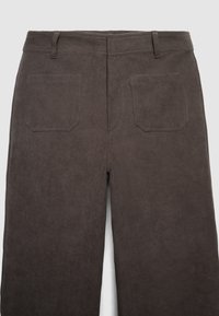 Braune Cord-Hosen mit gerippter Textur, ausgestattet mit zwei hinteren Taschen und einem Taillenbund mit horizontalen Streifen.