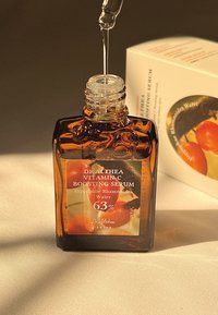 Botella de vidrio ámbar de suero potenciador de vitamina C de Dr. Althea con gotero, que presenta una etiqueta que destaca los ingredientes y el porcentaje.