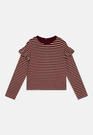 Koszula z długim rękawem w burgundowo-kremowe paski z falbanami na ramionach i okrągłym dekoltem, ułożona płasko na białym tle.