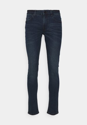 Jeans in denim blu scuro con una vestibilità slim. Le caratteristiche includono una chiusura con bottone, cinque tasche e una leggera sfumatura sulla parte anteriore.