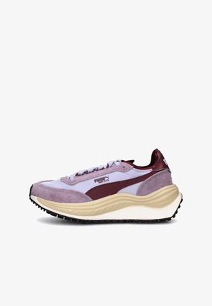 Sneakers viola e borgogna con tomaia in suede e mesh, una suola intermedia spessa color crema e suola esterna in gomma nera per la trazione. Marchio PUMA sul lato.