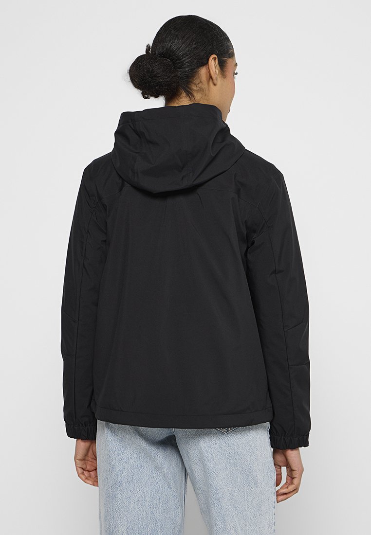 Giacca nera isolante con cappuccio, polsini elasticizzati e vestibilità rilassata. Caratterizzata da una texture liscia e un design minimale senza loghi visibili.