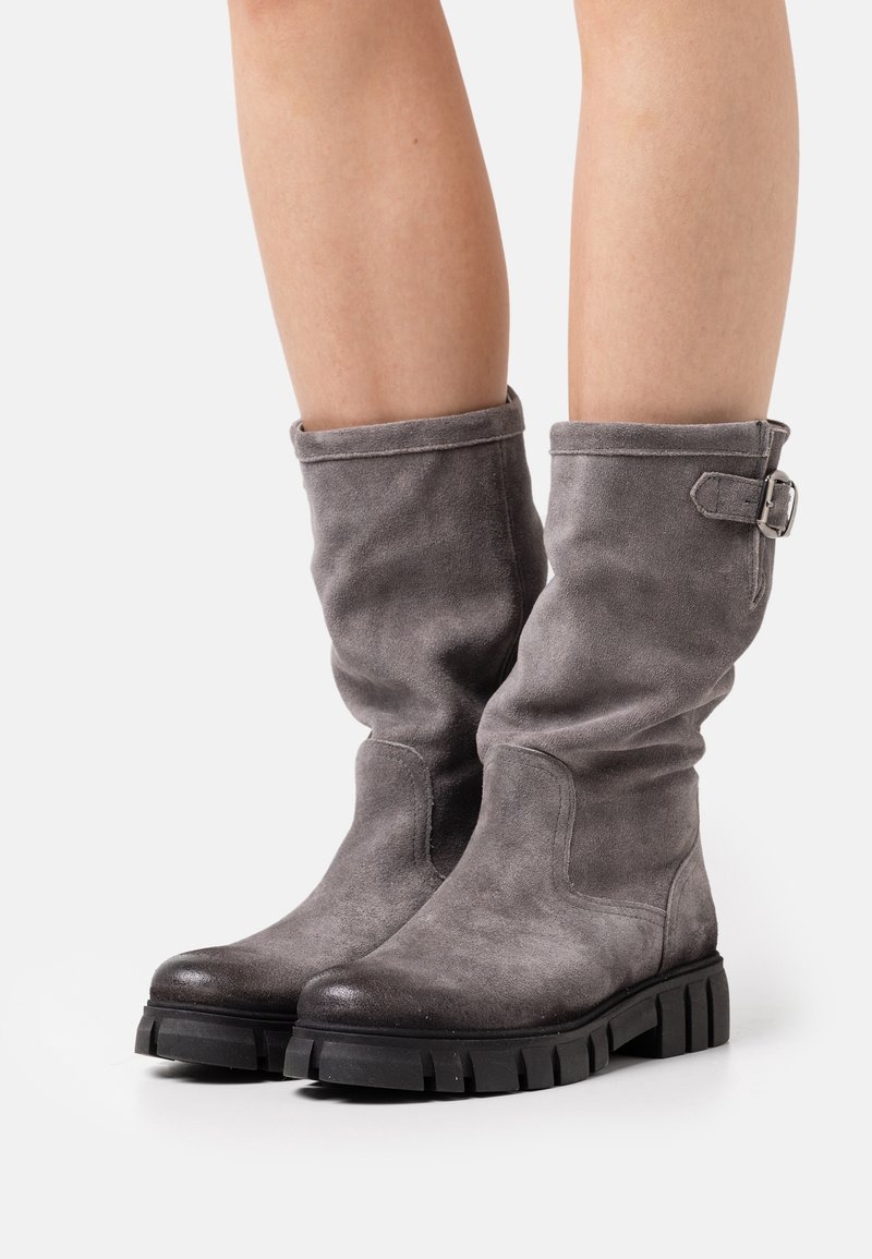 Botas de ante gris hasta la mitad de la pantorrilla con un diseño holgado, puntera redondeada y suela de goma negra con taco. Incluyen un adorno de hebilla lateral para estilo.