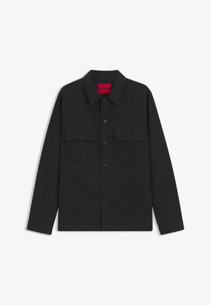 Black button-up shirt made of smooth fabric; features a collar, two chest pockets, and a red label inside the neckline.