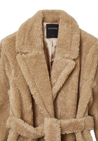 Cappotto in shearling beige peluche con colletto a scaldacuore, design doppiopetto e cintura in tessuto. Fodera in satin morbido.