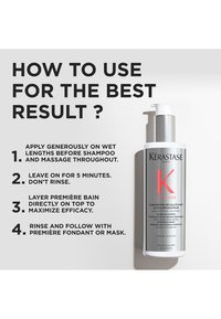 Kérastase hårbehandling i en silverfärgad flaska med pump, med röd text på en vit etikett. Instruktioner för användning är angivna.