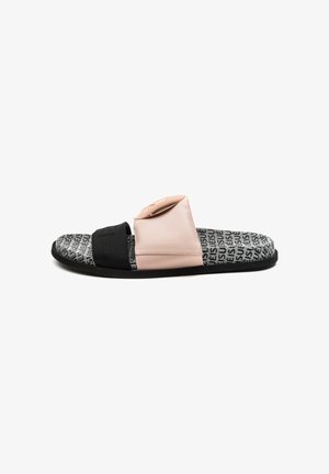 Slippers met zwarte en beige brede banden en een zwart-wit patroon op het voetbed met herhaald tekstontwerp.