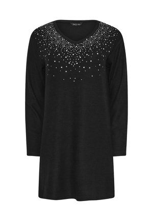 Túnica negra de manga larga con escote en V, que presenta un diseño en degradé de tachuelas plateadas en la parte superior del pecho. Textura de tela suave.