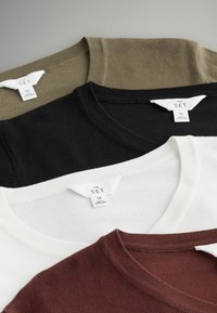 Neljä crew-neck t-paitaa oliivinvihreänä, mustana, valkoisena ja burgundinpunaisena, joissa on tarrat, joissa lukee "THE SET" ja koko "M". Pehmeä kangas näkyy selvästi.