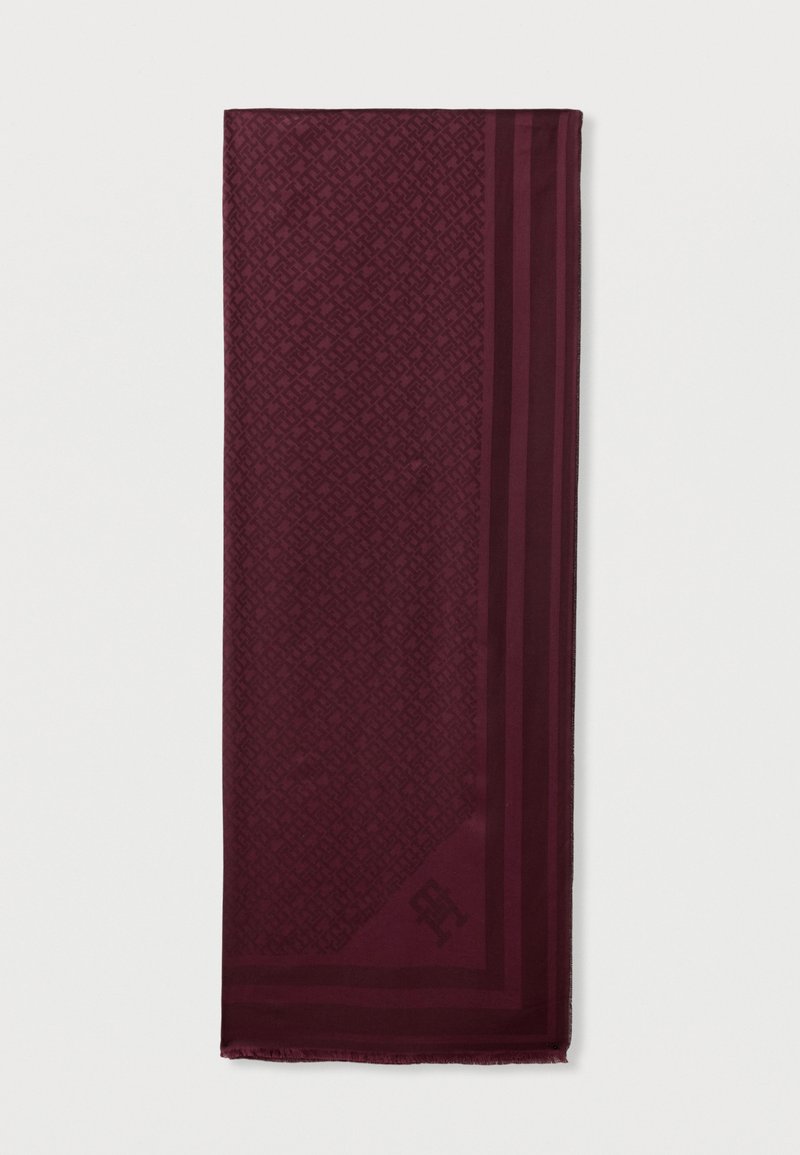 Écharpe bordeaux avec un motif géométrique et des bords unis. Texture lisse avec des bords effilochés et un logo dans un coin.