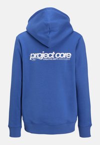 Zils kokvilnas hoodie ar kangoru kabatu, ribotām piedurknēm un lielu balto druku uz aizmugures, kas lasāma "project core CREATIVE DEPT."