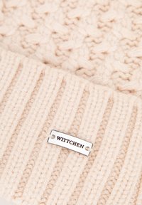 Cappello a maglia beige con motivo a trecce testurizzato, con bordo a coste e targhetta argentata incisa con "WITTCHEN."