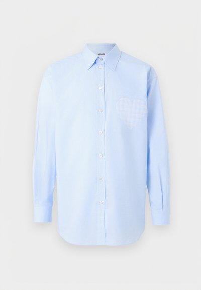 Ανοιχτό γαλάζιο πουκάμισο με μακριά μανίκια, κουμπιά μπροστά και μυτερό γιακά, με λεπτό καρό σχήμα καρδιάς στη θέση της αριστερής τσέπης στο στήθος.