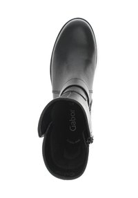 Bottine en cuir noir à tige courte présentant un bout rond, une fermeture éclair sur le côté et une doublure douce. Design minimaliste avec une texture lisse et des accents subtils.