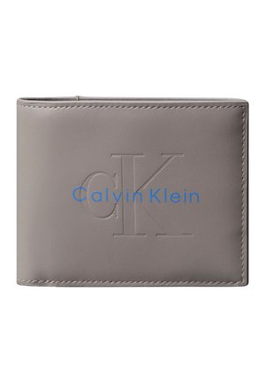 Cartera de cuero gris de doble plegado con iniciales "cK" en relieve y logo "Calvin Klein" en azul en la parte frontal.
