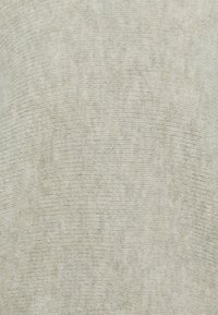 Pull en tricot gris clair avec une texture douce, présentant un motif fin et régulier et une coupe décontractée. Design simple sans ornements.