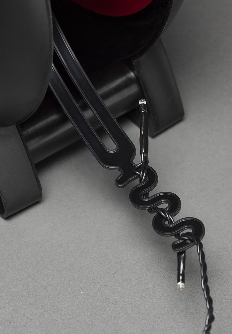 Cable de auriculares de plástico negro con un diseño en espiral, que presenta un extremo de conexión recto. Textura suave y sin patrones visibles.