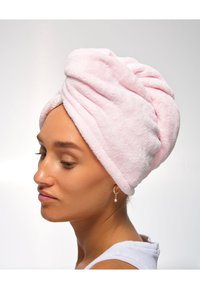 Rosa, fluffy håndkle pakket rundt hodet, med et vridd design. Myk tekstur og absorberende materiale, med synlige sømdetaljer.