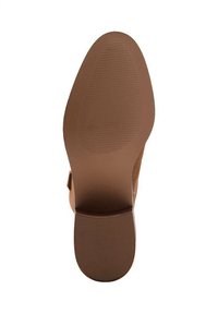 Suela de zapato de ante marrón con una superficie suave y sutiles estrías para tracción, que muestra una forma redondeada y un ligero tacón.