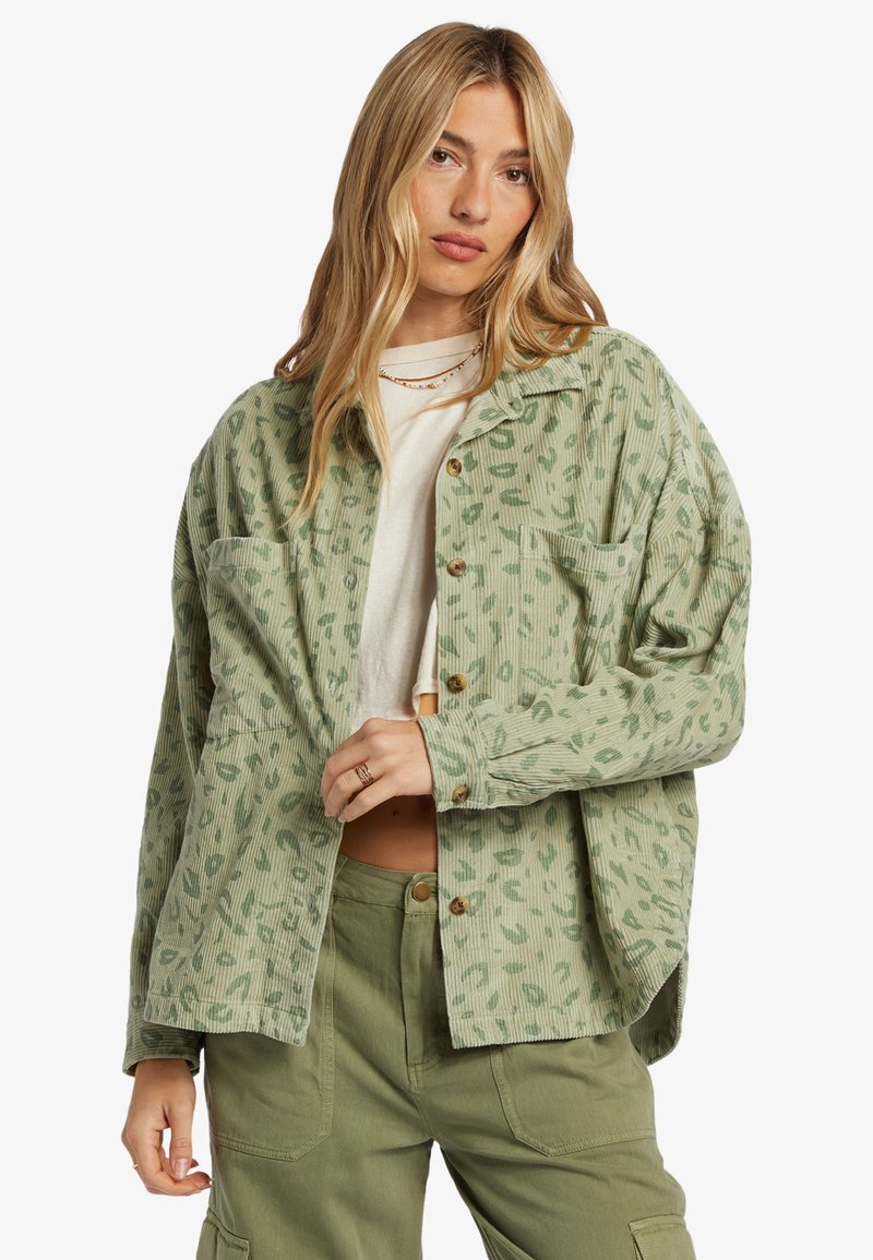 Camisa de pana verde claro con un patrón de leopardo, que cuenta con un cierre de botones, dos bolsillos en el pecho y un ajuste relajado.