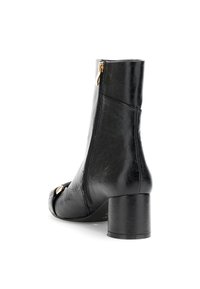 Stivale alla caviglia in pelle nera con punta squadrata, zip laterale e tacco spesso. Presenta una texture liscia e un accento in metallo color oro.