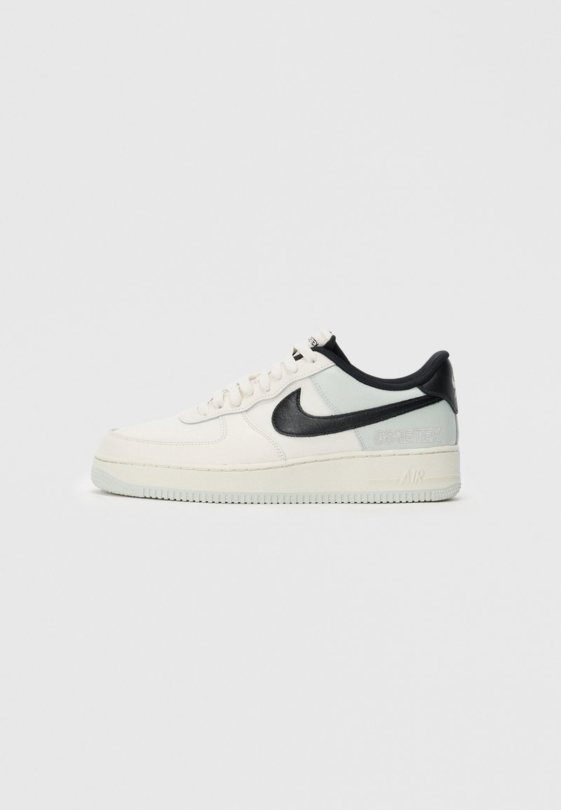 Niske Nike Air Force 1 tenisice u krem i svijetlo sivoj boji s crnim swoosh-om i Gore-Tex brandingom na bijeloj pozadini.