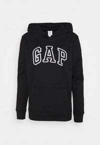 Sudadera negra de mezcla de algodón, con un bolsillo frontal y el logotipo blanco de "GAP" en letra negrita en el pecho. Textura suave, corte estándar.