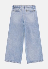 Vaqueros de pierna ancha de color azul claro hechos de mezclilla con una textura descolorida. Presentan una cintura alta, bolsillos traseros y dobladillo deshilachado.