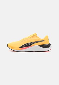 Scarpe da corsa gialle con tomaia testurizzata, accenti neri, una suola intermedia bianca e dettagli rossi nel tallone. Design leggero.